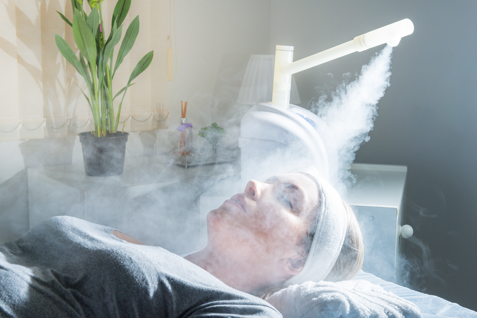 woman receiving face steam during her facial treatment